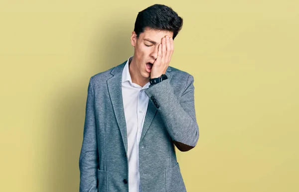 Young hispanic man wearing business clothes yawning tired covering half face, eye and mouth with hand. face hurts in pain.