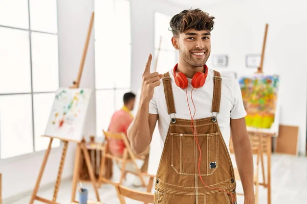 Joven Hombre Hispano Estudio Arte Señalando Con Dedo Hacia Arriba — Foto de Stock