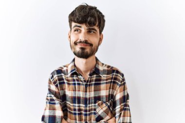 Sakallı İspanyol bir adam izole edilmiş arka planda duruyor. Gülümsüyor, yan tarafa bakıyor ve düşünüyor.. 