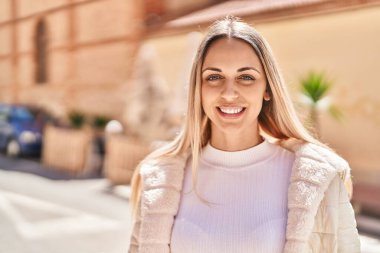 Sokakta kendinden emin gülümseyen genç bir kadın