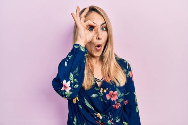 Kafkasyalı genç bir kadın günlük kıyafetler giyiyor. Şaşırmış bir yüz ve parmaklarından bakan bir gözle iyi bir hareket yapıyor. İnançsız ifade. 