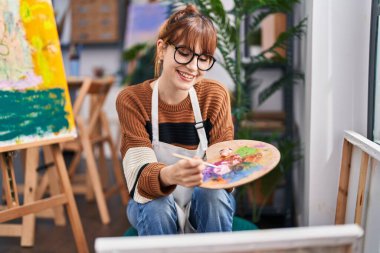 Young woman artist smiling confident drawing at art studio