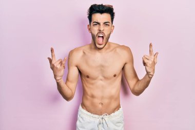 Mayo giyen, deli gibi bağıran genç İspanyol adam elleri havada rock sembolü yapıyor. Müzik yıldızı. ağır kavram. 