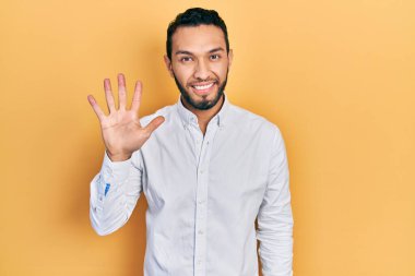 Sakallı, iş gömleği giyen İspanyol adam gülümseyen, kendinden emin ve mutlu beş numarayı işaret ediyor.. 