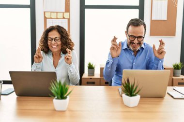İki orta yaşlı iş adamı mutlu bir şekilde gülümsüyor ve ofiste şans diliyor..
