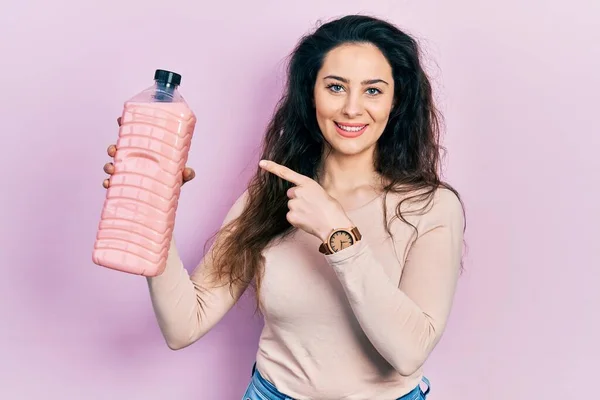 Ung Latinamerikansk Kvinna Håller Rengöringsmedel Flaska Ler Glad Pekar Med — Stockfoto