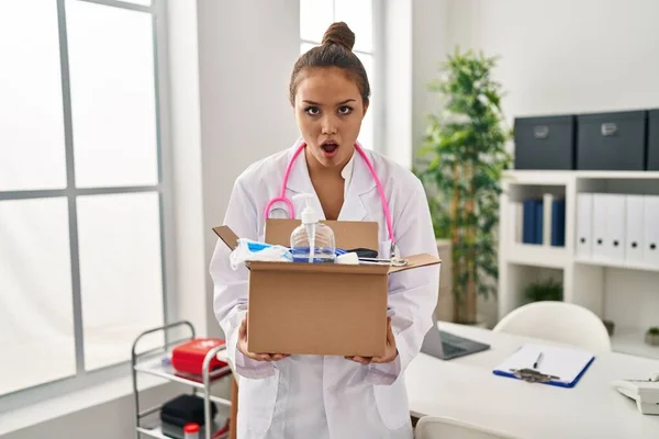 Young Hispanic Doctor Holding Box Medical Items Afraid Shocked Surprise — Stock Photo, Image