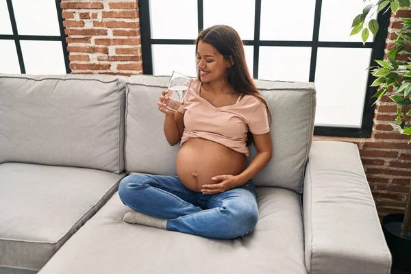 Młoda Latynoska Ciąży Pije Wodę Siedząc Kanapie Domu — Zdjęcie stockowe