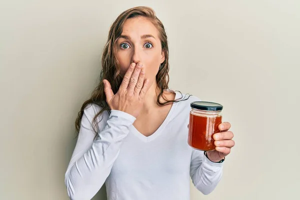 Young Blonde Woman Holding Jam Covering Mouth Hand Shocked Afraid — Stock Photo, Image