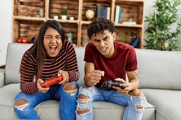 Young Latin Couple Unhappy Playing Video Game Sitting Sofa Home — Stock Fotó