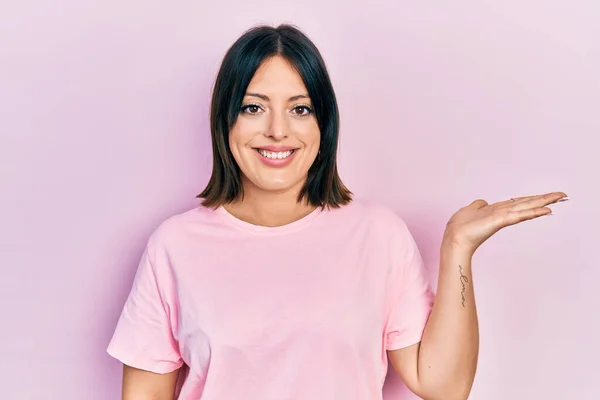 Junge Hispanische Frau Lässigem Rosafarbenem Shirt Lächelt Fröhlich Und Zeigt — Stockfoto