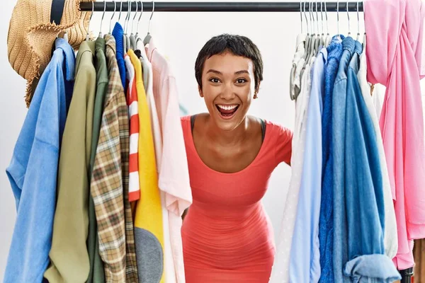 Joven Cliente Hispano Sonriendo Confiado Apareciendo Través Ropa Tienda Ropa —  Fotos de Stock