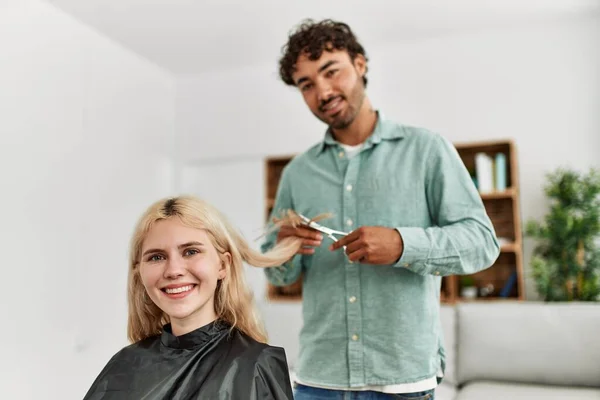 小伙子在家里给女朋友剪头发 — 图库照片
