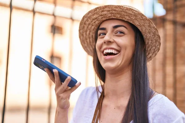 Young hispanic woman tourist smiling confident talking on the smartphone at street