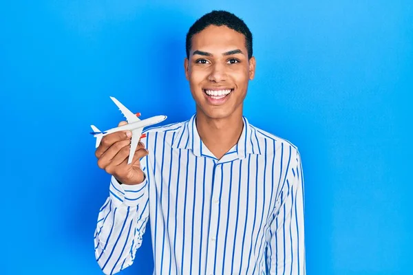 Young African American Guy Holding Airplane Toy Looking Positive Happy — Φωτογραφία Αρχείου