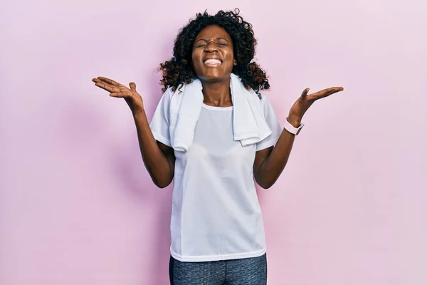 スポーツウェアとタオルを身に着けている若いアフリカ系アメリカ人女性は 腕を上げて興奮して叫んで目を閉じて成功のために狂気と狂気を祝います 勝者のコンセプト — ストック写真