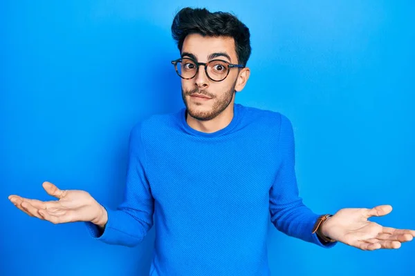 Mladý Hispánec Neformálním Oblečení Brýlích Bezradný Zmatený Výraz Zdviženýma Rukama — Stock fotografie