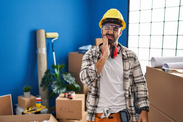 年轻的有胡子的恐慌性男人在家里工作 由于牙痛或牙病 用手触摸着嘴 表情很痛苦 — 图库照片