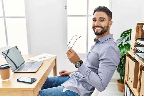 Young arab man smiling confident using laptop working at office