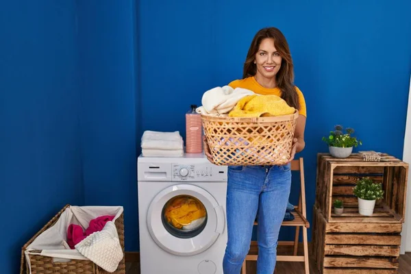 Young Latin Woman Smiling Confident Holding Basket Clothes Laundry Room — Stok fotoğraf