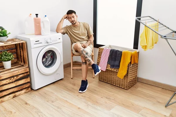 Young Hispanic Man Waiting Washing Machine Laundry Room — стоковое фото