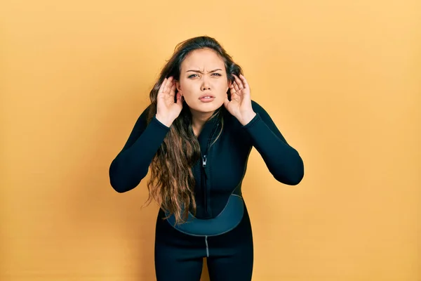 Joven Chica Hispana Usando Uniforme Neopreno Buceador Tratando Escuchar Ambos —  Fotos de Stock