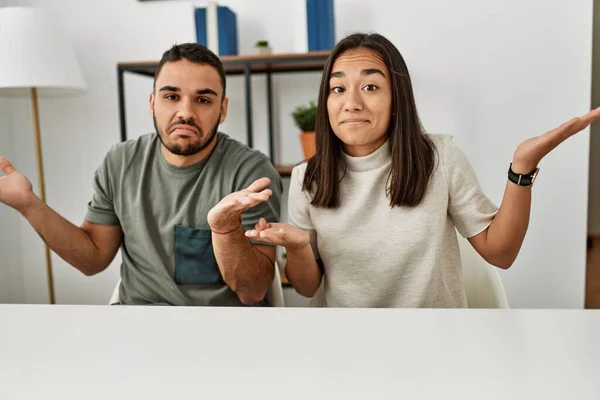 Unga Latinska Par Bär Casual Kläder Sitter Bordet Aningslösa Och — Stockfoto