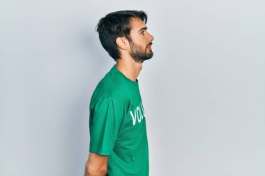 Gönüllü tişört giyen genç İspanyol bir adam profilini gevşetip doğal bir yüz ve kendine güvenen bir gülümsemeyle poz veriyor.. 