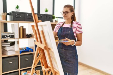Sanat stüdyosunda kendine güvenen genç bir kadın.