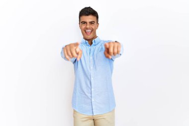 İspanyol gömlekli genç adam izole edilmiş arka planda dikiliyor. Seni ve kamerayı işaret ediyor. 