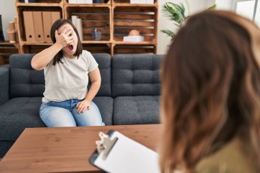 Down sendromlu İspanyol kız şok tedavisi uyguluyor. Yüzü ve gözleri kapayarak, utangaç ifadesiyle parmaklarından bakıyor.. 