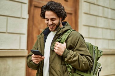 Şehirde akıllı telefon kullanan yakışıklı bir İspanyol.