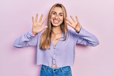 Gündelik tişört giyen güzel İspanyol kadın dokuz numarayı gösterip işaret ederken kendinden emin ve mutlu bir şekilde gülümsüyor.. 