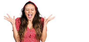 Gündelik kıyafetler giyen genç İspanyol kız başarı için deli ve çılgınlığı kutluyor kollarını kaldırmış ve gözlerini kapatmış heyecanla bağırıyor. Kazanan konsept 