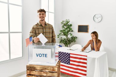 Genç Amerikalı seçmen seçim kurulunda oy sandığına koyuyor..