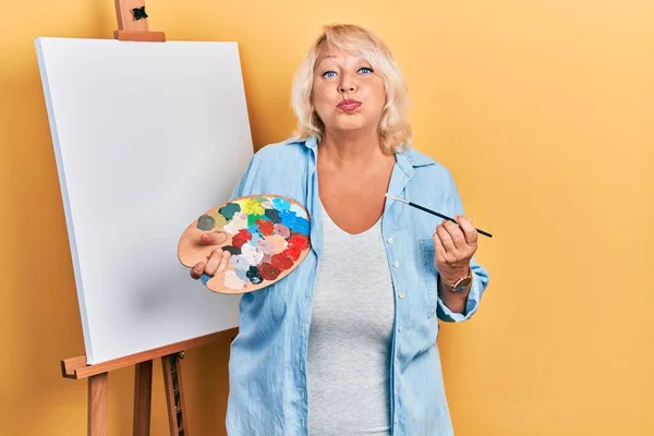 Middle Age Blonde Woman Standing Drawing Palette Painter Easel Stand — ストック写真