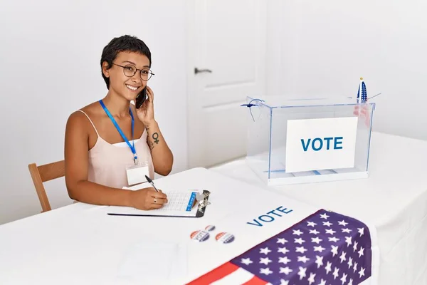選挙大学で働くスマートフォンに自信を持って話している若いヒスパニック系の女性 — ストック写真