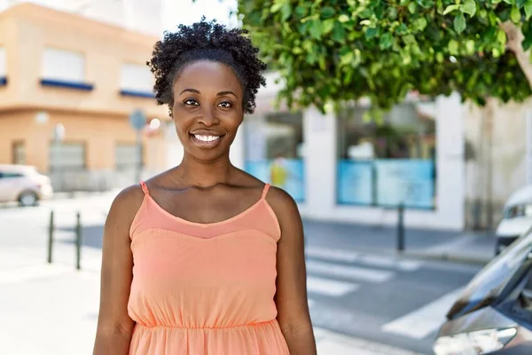 Young african american woman smiling happy at the city on a summer day