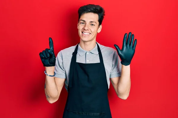 Young Hispanic Man Wearing Apron Showing Pointing Fingers Number Six — Stock Photo, Image