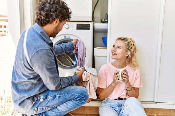 Jovem Casal Sorrindo Feliz Beber Café Enquanto Lavava Roupa Casa — Fotografia de Stock