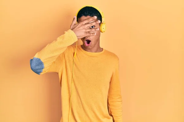Young African American Guy Listening Music Using Headphones Peeking Shock — Fotografia de Stock