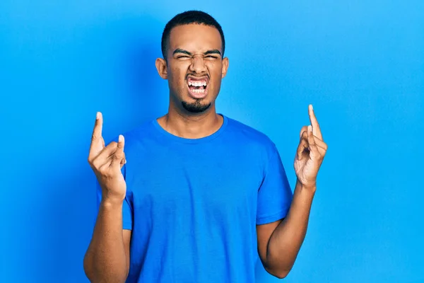 Joven Hombre Afroamericano Vistiendo Casual Camiseta Azul Gritando Con Expresión —  Fotos de Stock