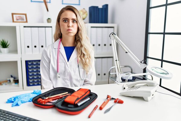 Young Beautiful Doctor Woman Reflex Hammer Medical Instruments Puffing Cheeks Stock Picture