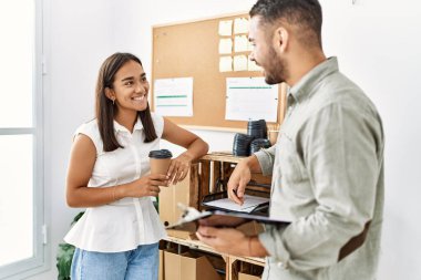 İki Latin iş adamı panoya yazı yazıp ofiste kahve içiyorlar..