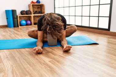 Genç İspanyol sporcu adam spor merkezinde esneme hareketleri yapıyor..