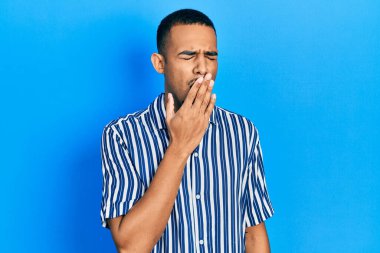 Gündelik giysiler giyen genç Afro-Amerikalı adam ağzını eliyle kapatmaktan sıkıldı. Huzursuz ve uykulu.. 