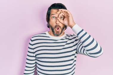 Orta yaşlı, sıradan kıyafetler giyen, şaşırmış yüz ifadesiyle şaşırmış, parmaklarından bakan beyaz bir adam. İnançsız ifade. 