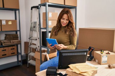 Ofiste dokunmatik ped kullanan genç Latin bir iş kadını.