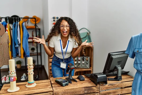 Giyim mağazasında çalışan güzel İspanyol kadın zaferi mutlu bir gülümseme ve kazanan yüz ifadesiyle kutluyor. 