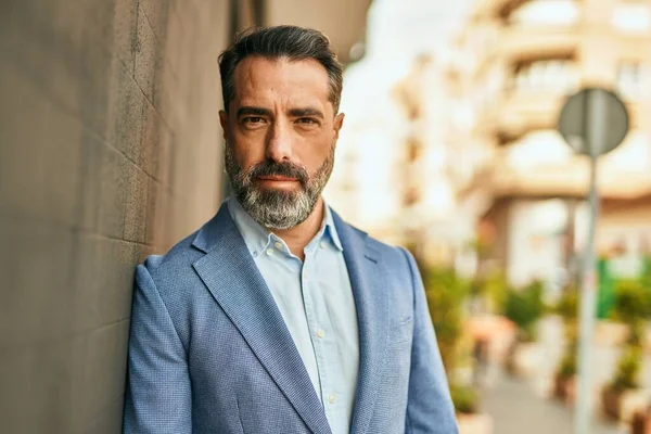 Şehirde duran rahat yüzlü orta yaşlı iş adamı..